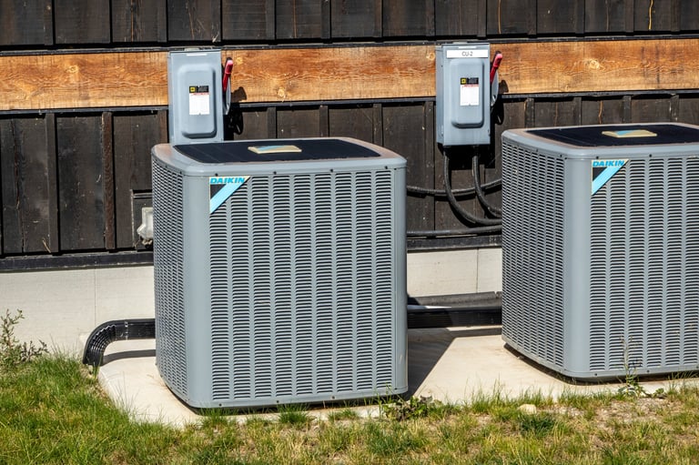 Two Daikin outdoor air conditioning units installed side by side on concrete pad