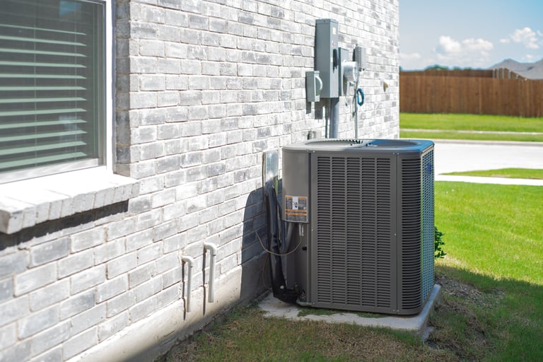 AC condenser unit mounted on brick house wall in Dallas Texas suburbs