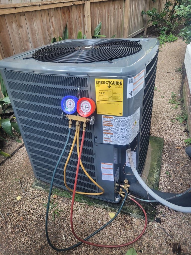 Outdoor AC condenser unit with gauges and service hoses attached, yellow EnergyGuide label visible on black compressor